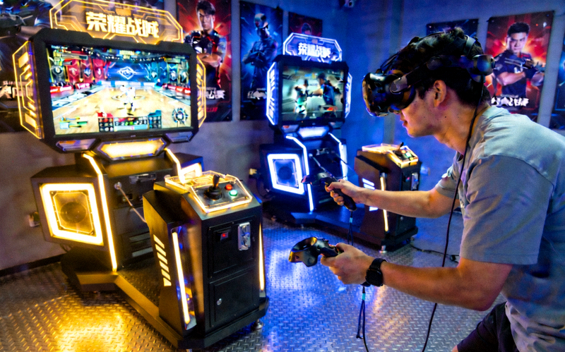 游客在荣耀殿堂的互动体验区使用VR设备重温经典决赛瞬间